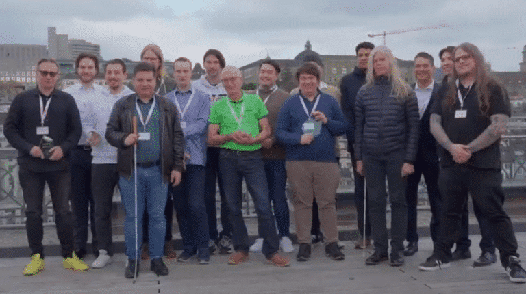 Gruppenfoto der Teilnehmer des Hackathon 2025 auf der Straße vor einem Geländer.
