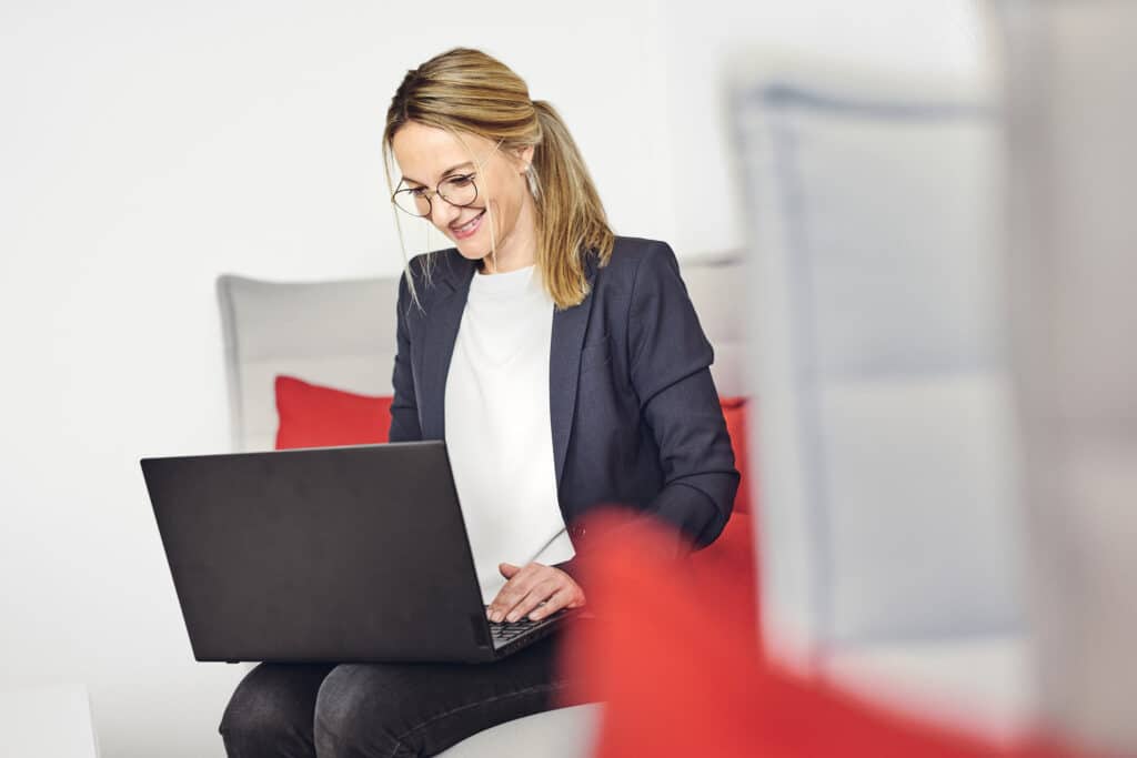 Celine Spitz arbeitet an ihrem Laptop auf dem Sofa in der kwsoft-Lounge.