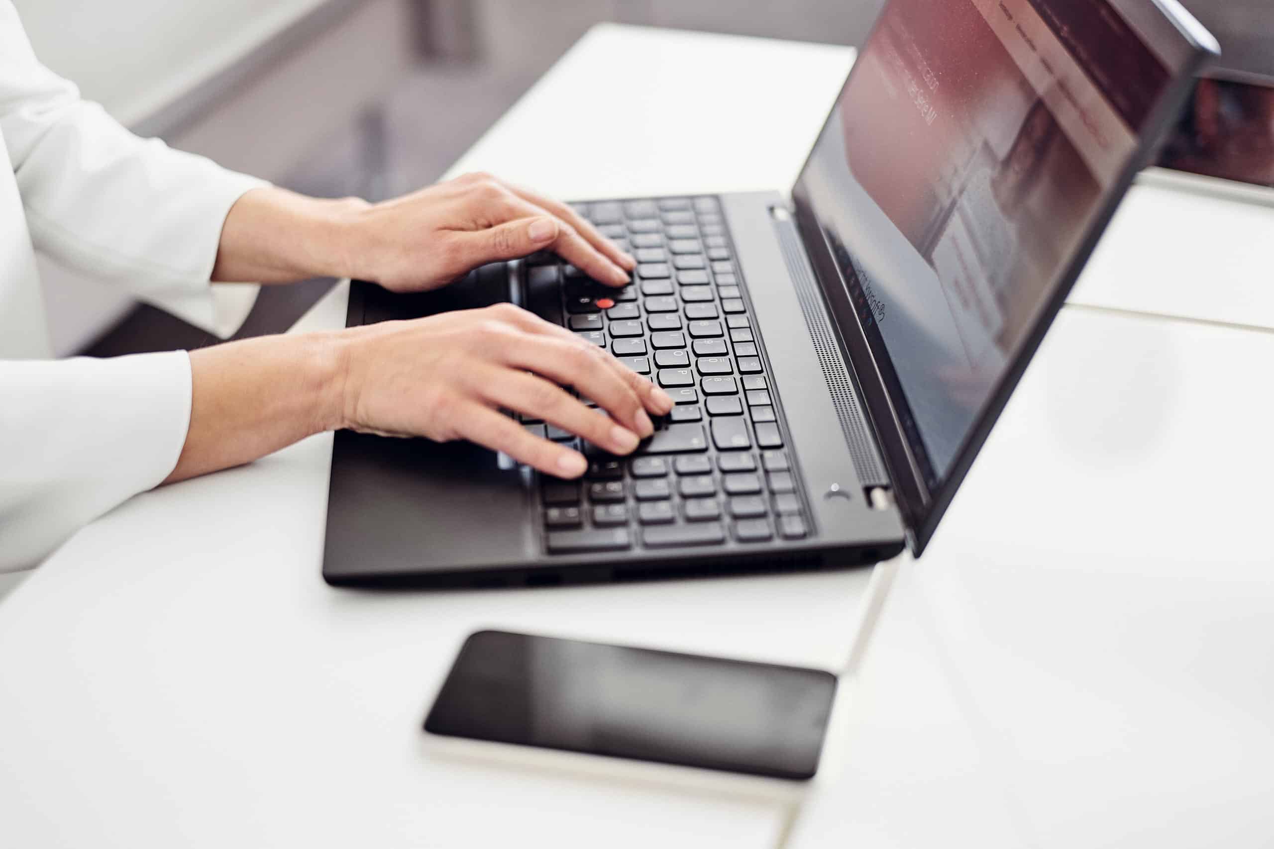 Eine Person sitzt an einem Laptop und besucht die kwsoft Website.