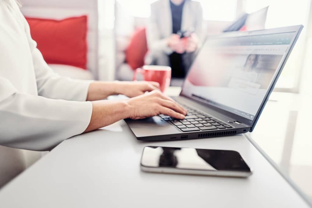 Eine Person sitzt an einem Laptop und besucht die kwsoft Website.