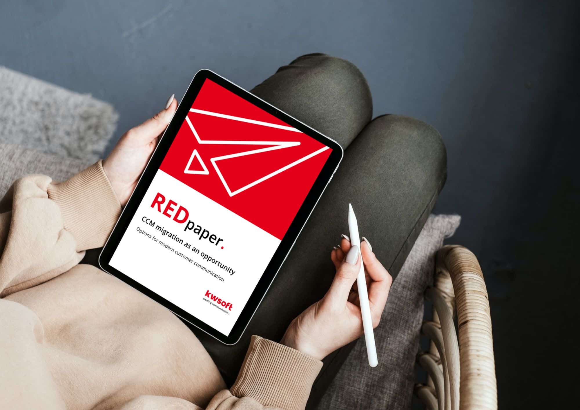 Das Bild zeigt ein Tablet, das von jemandem gehalten wird und auf dem das Cover des REDpaper „CCM – Migration” zu sehen ist.